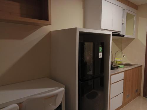 a kitchen with a black refrigerator in the corner at MESA Thamrin City Apartments at Nagoya with Netflix & Pick Up Service in Nagoya