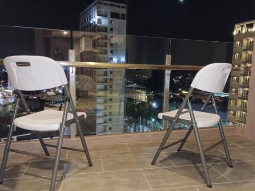 two white chairs sitting on top of a building at Free Shuttle Thamrin City Apartments at Nagoya with Netflix & Youtube Premium by MESA in Nagoya