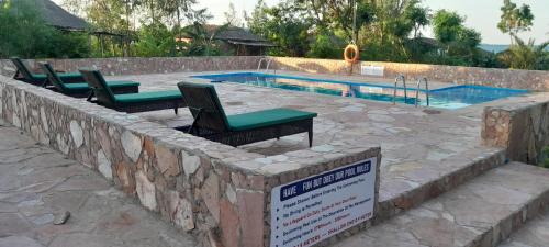 a swimming pool with chairs and a sign in front of it at Mwanza lake view FARM Eco LODGE in Sengerema