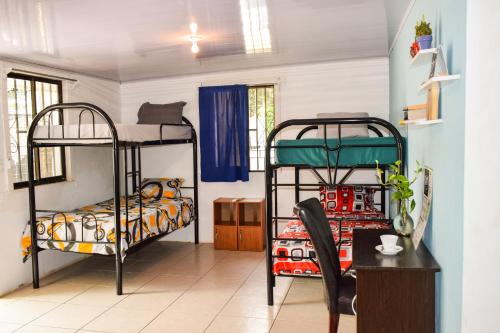 een kamer met 2 stapelbedden en een bureau bij CAPRICHOS Rooms in Tamarindo