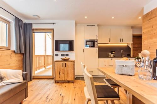 a kitchen and dining room with a large wooden table at Apartments Milanhof in Ortisei