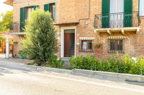 a brick house with a tree in front of it at Casa Vacanze Mongili - Il Moro in Chiusi