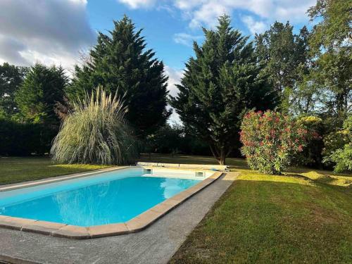 a swimming pool in a yard with trees at Maison de charme au pays du vin - Charming House in Wine Country in Montcaret