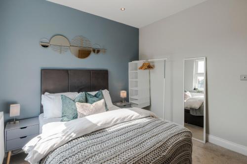 a bedroom with a large bed with blue walls at Stunning 3 Bed Duplex Apartment in the heart of West Hampstead in London