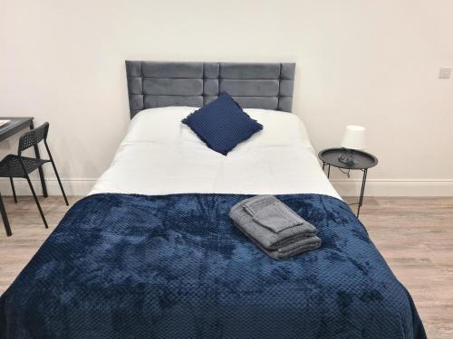 a bed with a blue comforter and a blue blanket at Homestay by BIC Legends 5 in Batley Carr