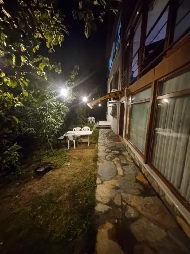 a yard with a table and a building at night at SNOW HİLL HOUSE Pansiyon in Kartepe
