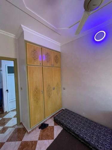 Habitación con armarios de madera y ventilador de techo. en Luxurious appartement en Oujda