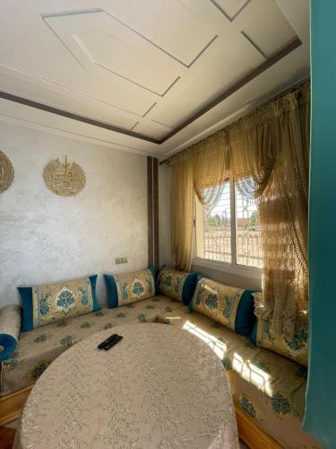 a living room with a couch and a large window at Luxurious appartement in Oujda