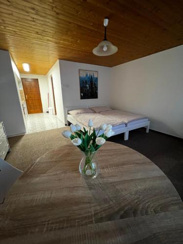a room with a bed and a vase of flowers on a table at Květinová in Litoměřice