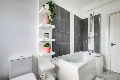a bathroom with a white tub and a toilet at Redditch 4 Bed 3 Bath From 21 PP Per Night 5 Star in Redditch
