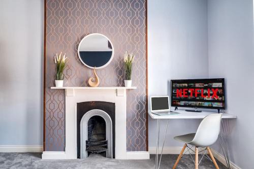 a room with a fireplace with a desk and a mirror at Redditch 4 Bed 3 Bath From 21 PP Per Night 5 Star in Redditch