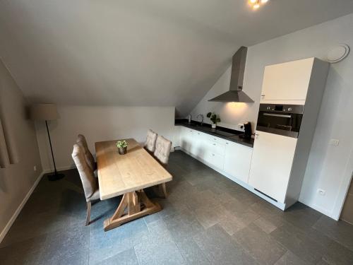 eine Küche mit Tisch und Stühlen und einem Kühlschrank in der Unterkunft Bolderhuys in Bolderberg