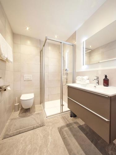 a bathroom with a shower and a sink and a toilet at Gästehaus Kulmer in Hopfgarten im Brixental