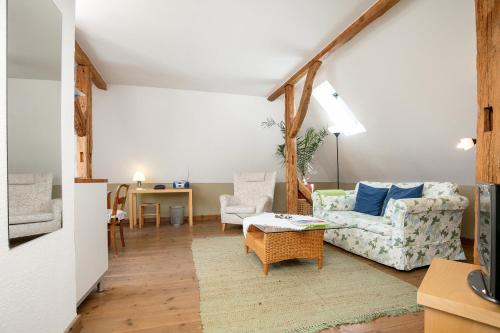 ein Wohnzimmer mit einem Sofa und einem Tisch in der Unterkunft Gutshaus Ketelshagen in Putbus