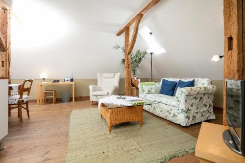 ein Wohnzimmer mit einem Sofa, Stühlen und einem Tisch in der Unterkunft Gutshaus Ketelshagen in Putbus