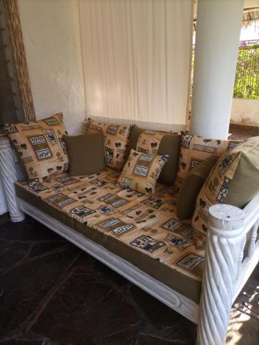 un sofá con almohadas en una habitación en Sophia house, en Malindi