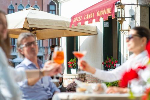 a group of people sitting at a table with drinks at Canal Grande in Venice