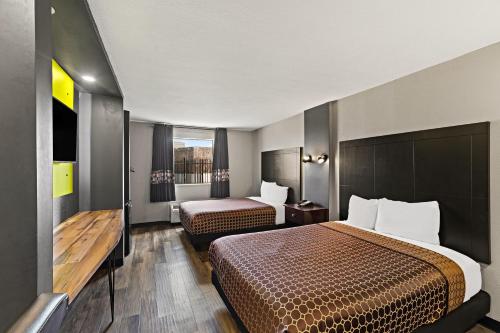a hotel room with two beds and a window at Scottish Inns Austin Downtown in Austin
