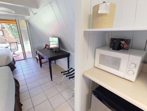 a room with a kitchen with a microwave and a table at Hotel Moloka'i in Kaunakakai