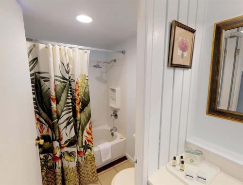 a bathroom with a shower curtain with a toilet at Hotel Moloka'i in Kaunakakai