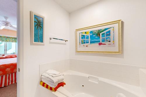 a white bathroom with a tub and a bed at Villa Del Mar in Corolla