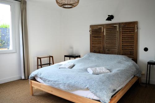 a bedroom with a bed with two pillows on it at La maison de la plage, à 350m de la mer, jardin in Asnelles