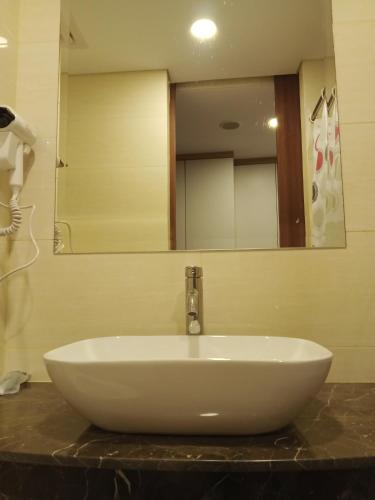 a white sink in a bathroom with a mirror at MESA Thamrin City Apartments at Nagoya with Netflix & Pick Up Service in Nagoya
