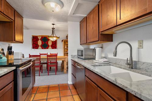 a kitchen with a sink and a counter top at Fort Marcy Suites by All Seasons Resort Lodging in Santa Fe