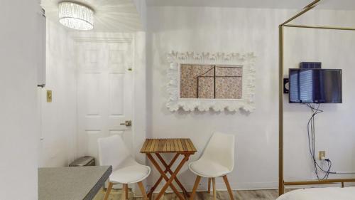 een woonkamer met witte muren en een tafel en stoelen bij Exclusive Access to a Gorgeous Private Beach 1BR in St Pete Beach