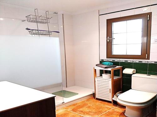 uma casa de banho com um chuveiro e um WC. em Villa El Suspiro Frigiliana Nerja em Frigiliana