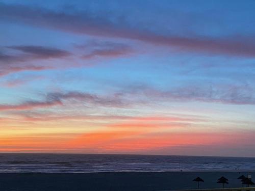 a sunset on the beach with the ocean at Apart. Dunas da Torreira in Torreira