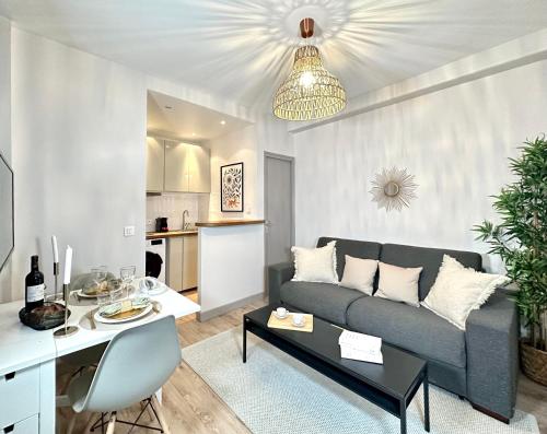 ein Wohnzimmer mit einem Sofa und einem Tisch in der Unterkunft 2067 - Elegant home in Trocadéro Olympic Games 2024 in Paris