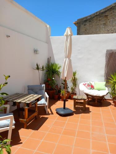 a patio with a table and an umbrella and chairs at Casa da Umbria in Odemira