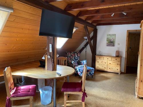 ein Wohnzimmer mit einem Tisch mit Stühlen und einem TV in der Unterkunft Landhotel Garni Knittelsheimer Mühle in Knittelsheim