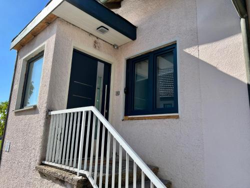a house with a white staircase and a window at Ferienwohnung Pfaffensteinblick in Hirschbach