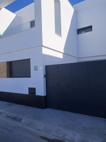 a building with black doors on the side of it at APARTAMENTO TURISTICO EN LEBRIJA in Lebrija