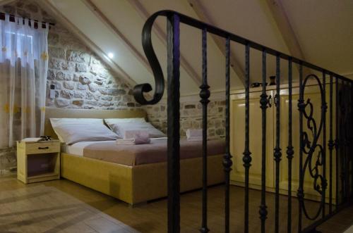 a bed in a room with a stone wall at Apartments Kaja in Trogir