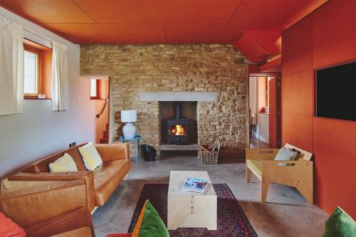 a living room with a couch and a fireplace at A Digital Detox in the Cotswolds - Langley Barn in Winchcombe