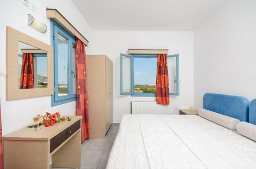 a bedroom with a bed and two windows at Apartments Naxos Camping in Naxos Chora