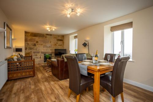 a dining room and living room with a table and chairs at Swallow View, A Spacious Base with stunning views in Matlock