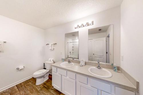 ein Badezimmer mit zwei Waschbecken, einem WC und einem Spiegel in der Unterkunft Arbor Retreat in Jacksonville