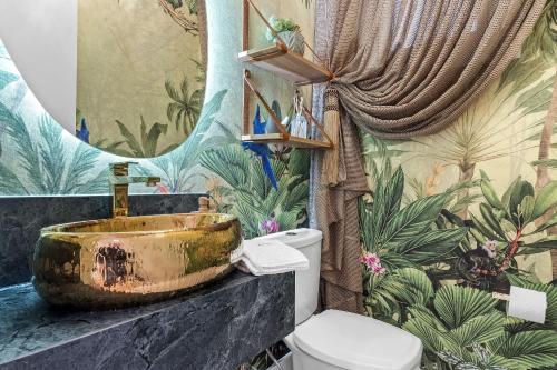 a bathroom with a sink and a toilet at Apartamento Bellagio 2 Suítes e Piscina by Achei in Canela