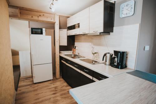 a kitchen with a white refrigerator and a sink at Oāze Ģimenei in Pāvilosta