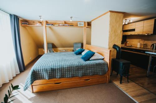 a bedroom with a bed with blue pillows at Oāze Ģimenei in Pāvilosta