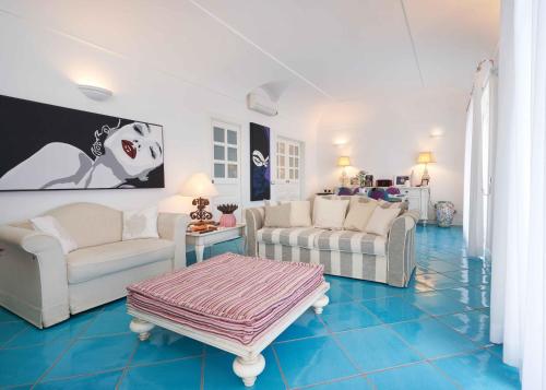 a living room with white furniture and a blue tile floor at fior di lino in Positano