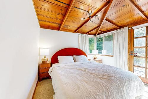 1 dormitorio con 1 cama grande y cabecero rojo en Cozy Riverview Cabin, en Forestville