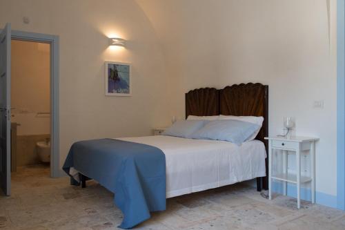 1 dormitorio con 1 cama y baño con aseo en Masseria del Poeta by BarbarHouse, en Ceglie Messapica