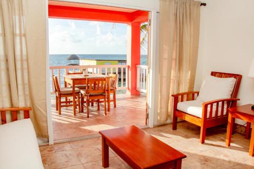 a living room with a table and chairs and the ocean at Mayan Princess Hotel in San Pedro