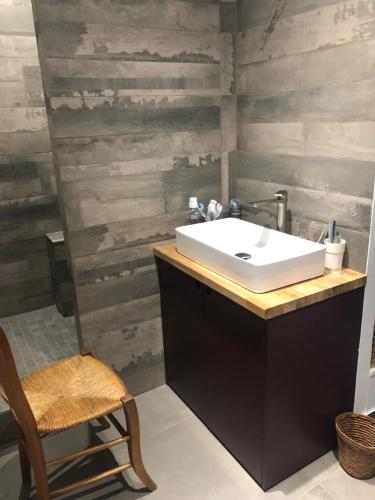 La salle de bains est pourvue d'un lavabo et d'un mur en bois. dans l'établissement Charming apartment on top floor in Marais -5P, à Paris