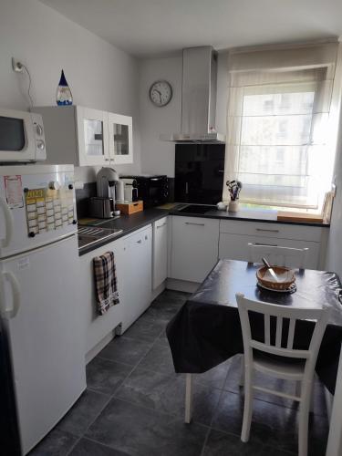 une cuisine avec des appareils électroménagers blancs et une table et une table et une chaise dans l'établissement T2 calme logement entier 45 m² sur Debourg/Gerland, à Lyon
